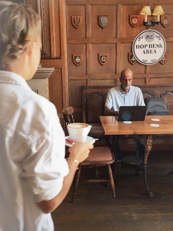 A pub landlord welcoming daytime workers to a table